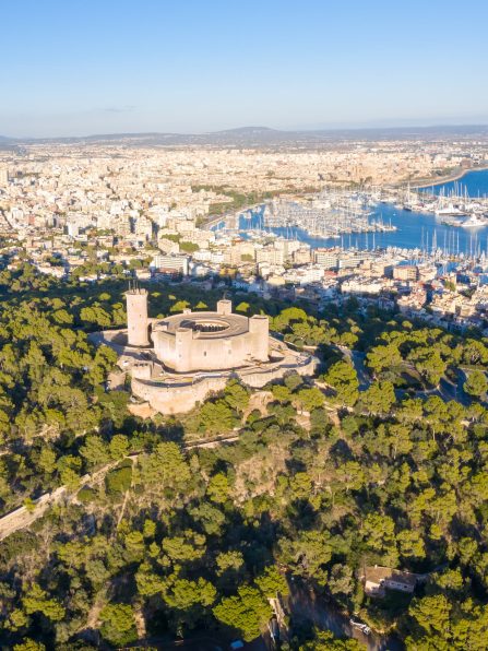 Castell de Bellver castle with Palma de Mallorca and harbor travel traveling holidays vacation aerial photo view portrait format in Spain